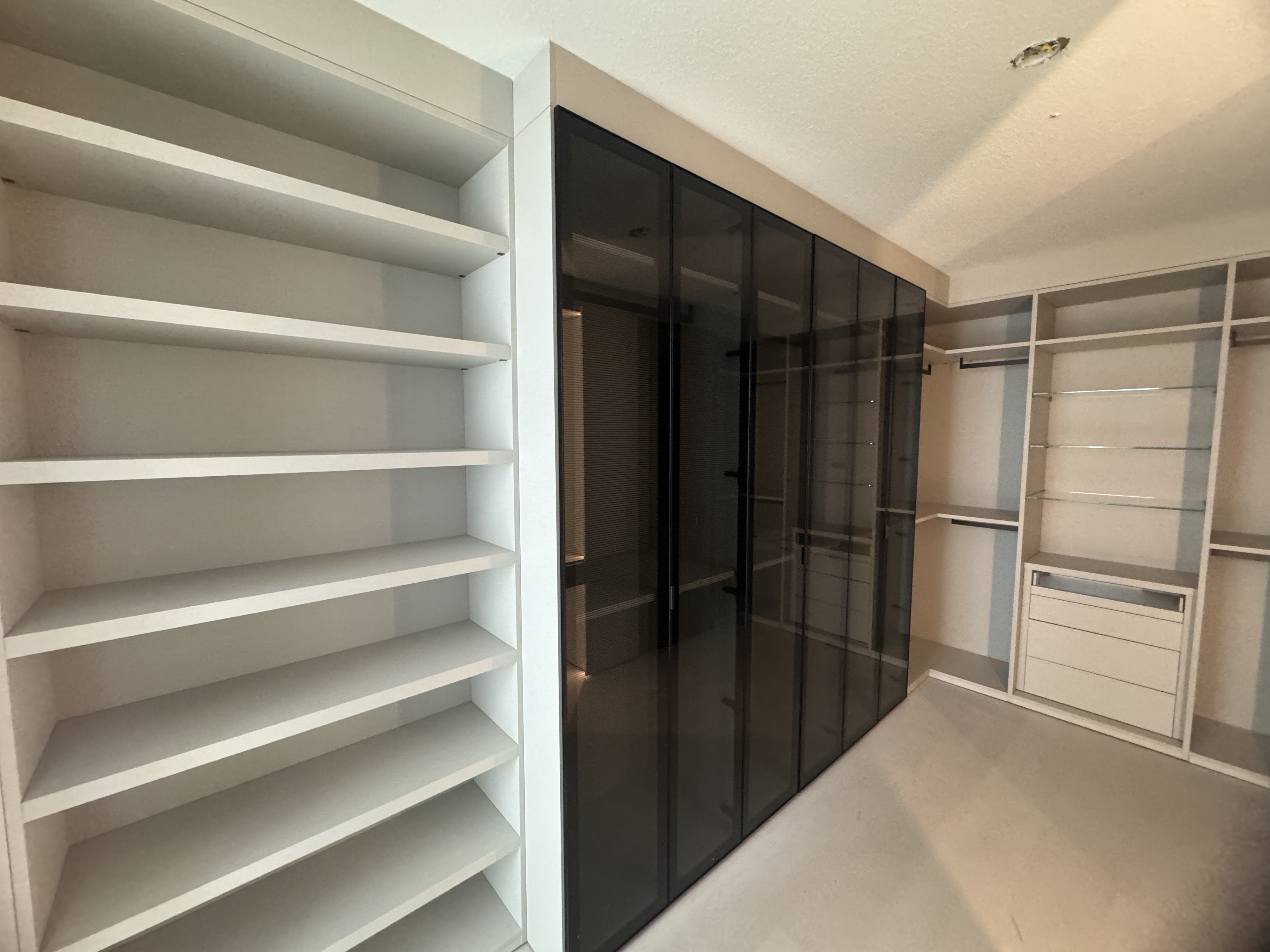 After: Refined custom closet system with integrated TV space, improved symmetry, and optimized storage
